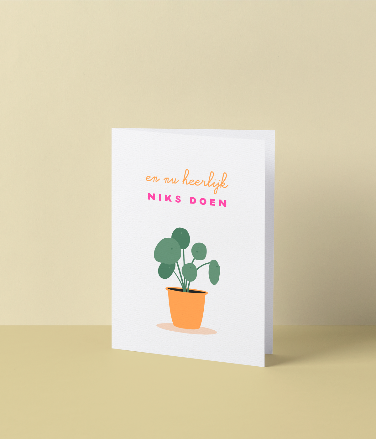 Witte wenskaart met een kamerplant in een oranje pot en de tekst ‘En nu heerlijk niks doen’ in fluo roze letters