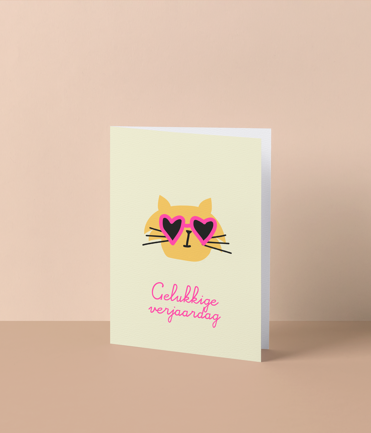 Gele wenskaart met een gele kat met roze hartjesbril en de tekst ‘Gelukkige verjaardag’ in fluo roze letters