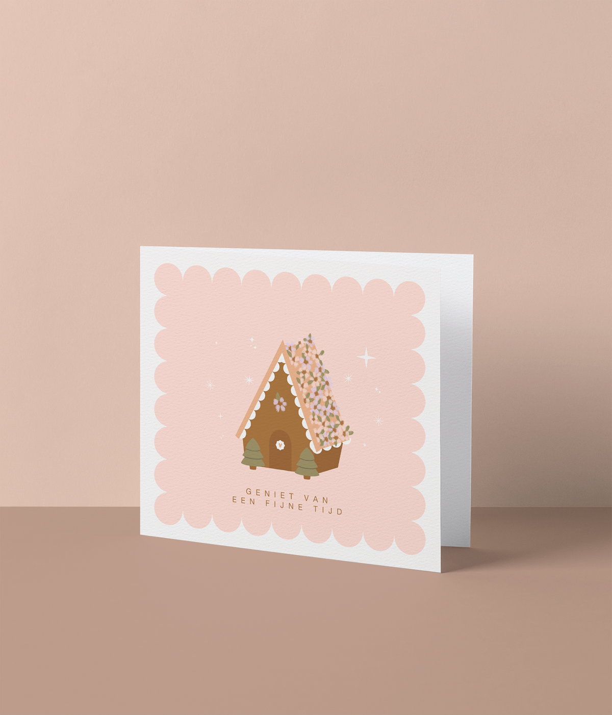Kerstkaart met illustratie van een peperkoekhuisje met bloemendak op roze scalloped achtergrond en de tekst 'geniet van een fijne tijd', losse kaart van Studio Mie