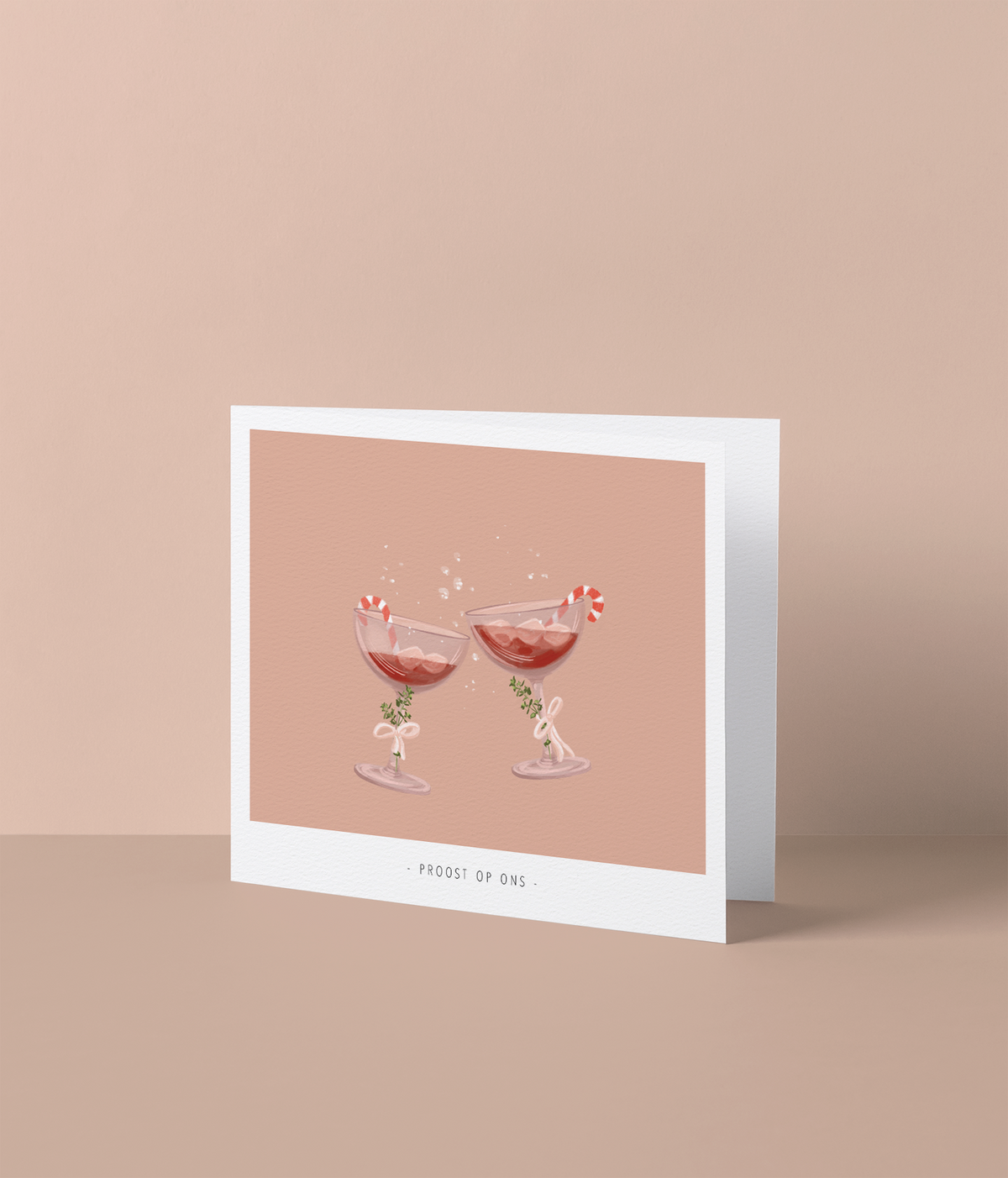 Kerstkaart met klinkende cocktailglazen en zuurstokjes