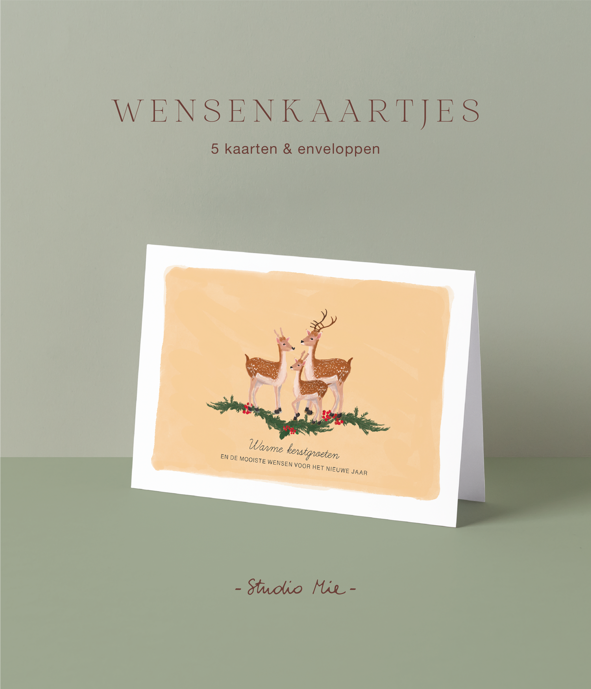 Kerstkaart met illustratie van een hertenfamilie tussen dennengroen en hulst op perzikkleurige achtergrond en de tekst 'warme kerstgroeten en de mooiste wensen voor het nieuwe jaar', set van 5 wenskaartjes van Studio Mie
