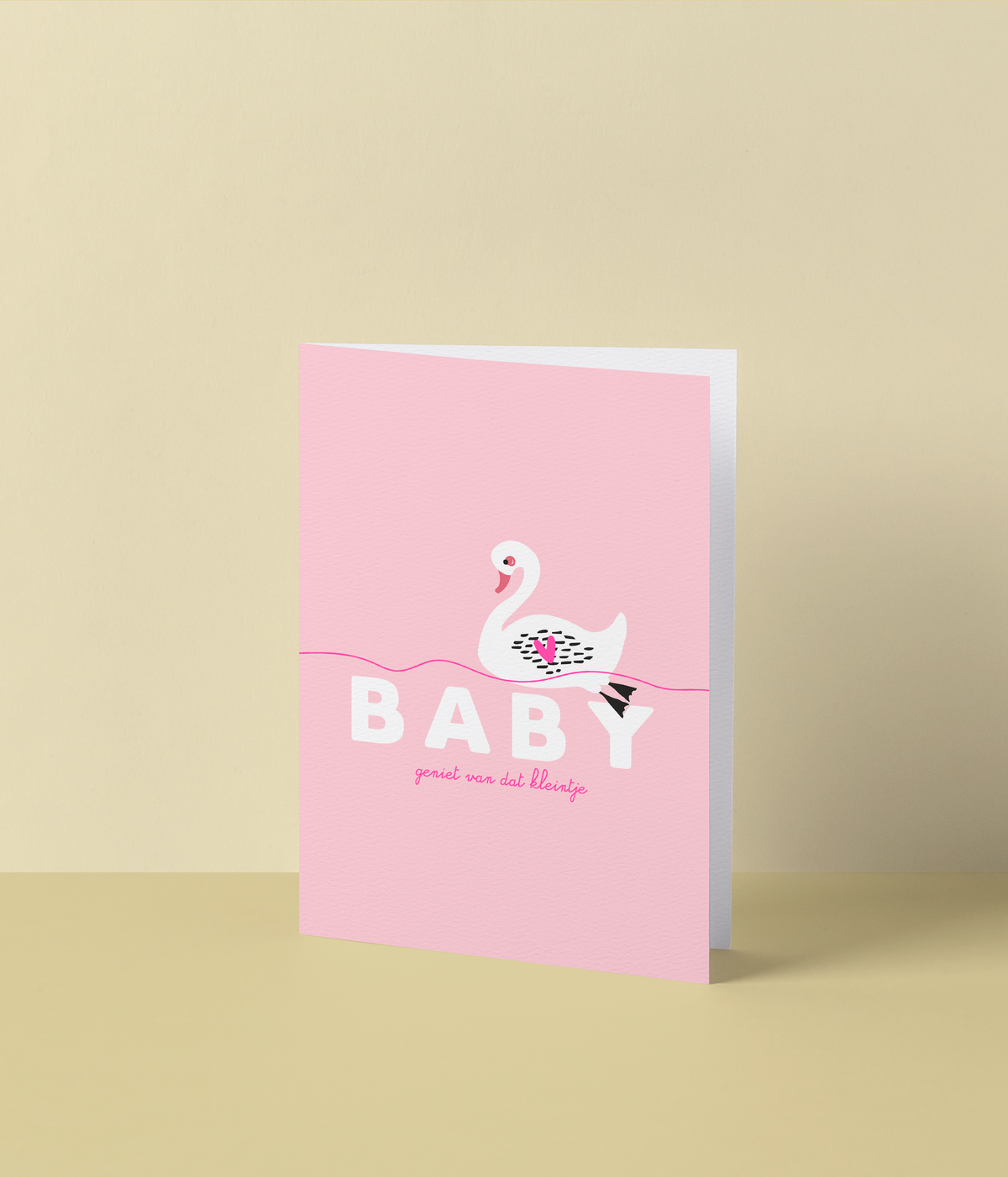 Roze wenskaart met een witte zwaan op het water en de tekst ‘Baby, geniet van dat kleintje’ in fluo roze inkt