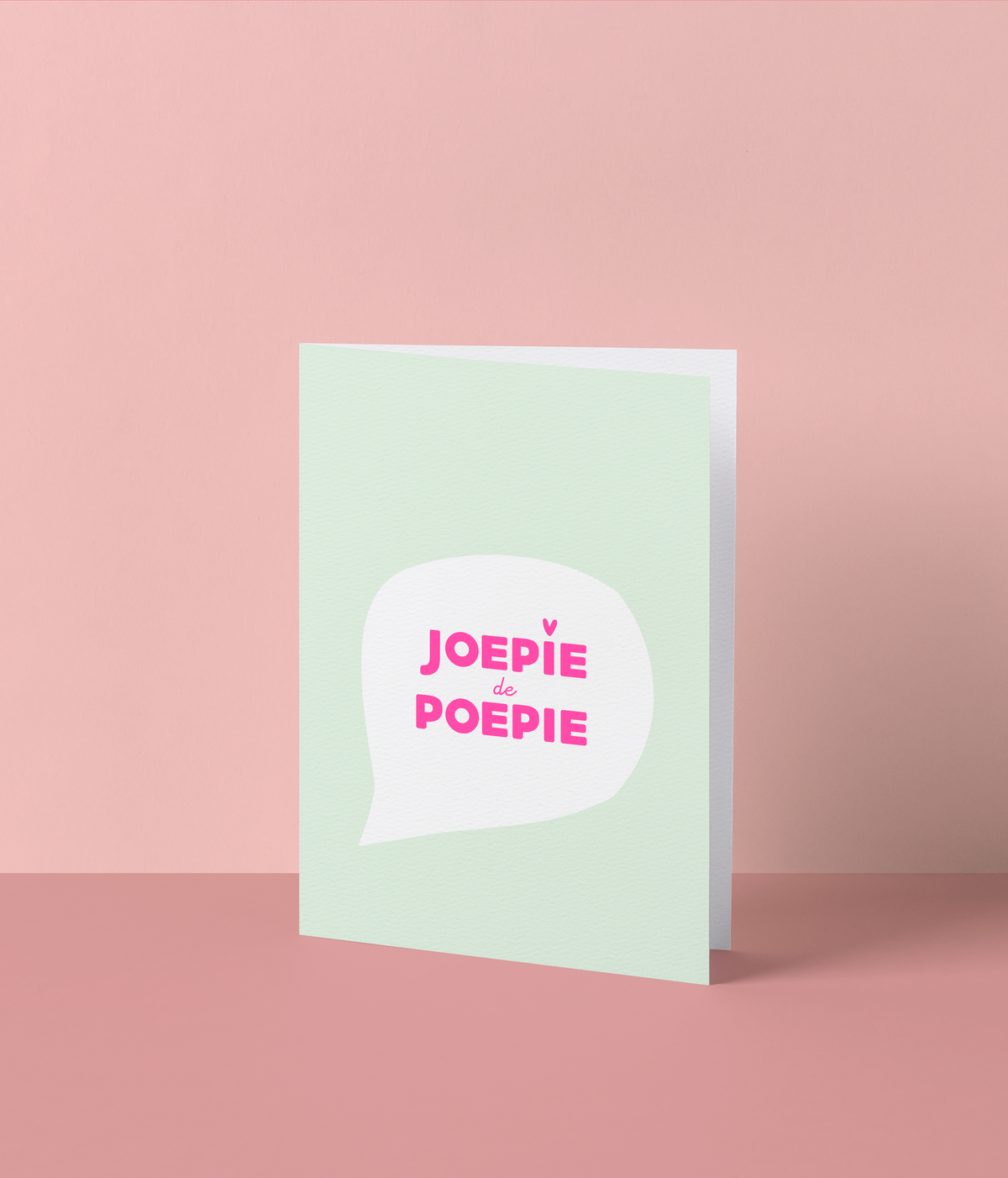 Muntgroene wenskaart met een witte tekstballon en de tekst ‘Joepie de poepie’ in fluo roze inkt
