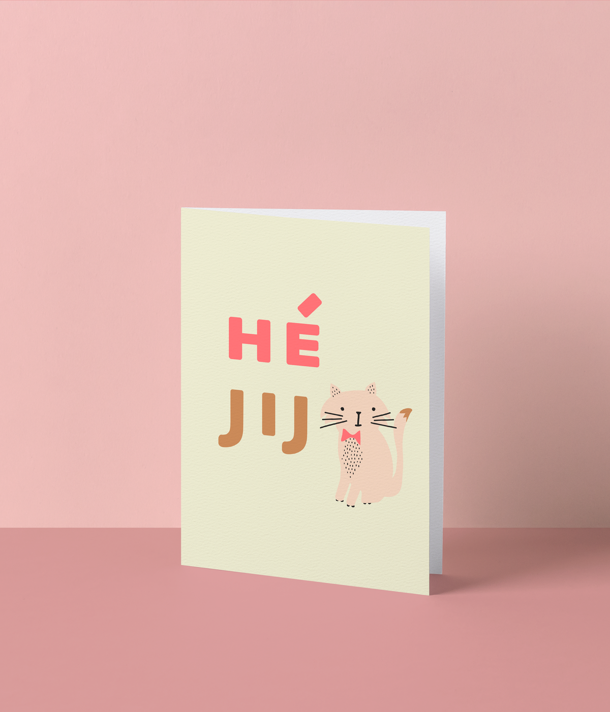 Lichtgele wenskaart met een katje met roze strikje en de tekst ‘Hé jij’ in fluo roze en bruine letters