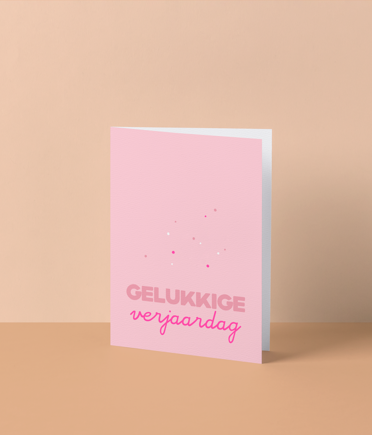 Roze wenskaart met kleine confettistippen en de tekst ‘Gelukkige verjaardag’ in fluo roze letters