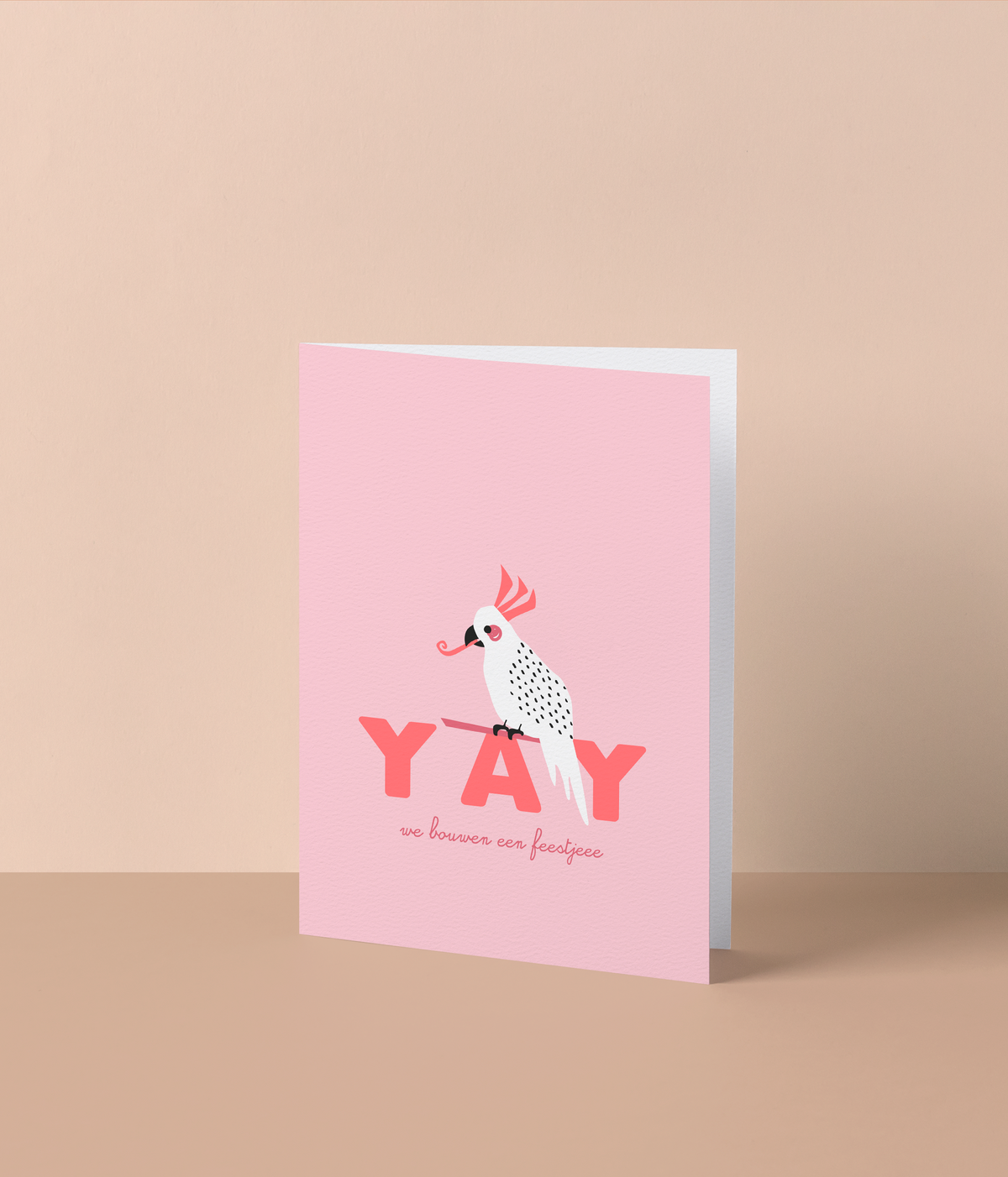 Roze wenskaart met een witte kaketoe met feesttoeter en de tekst ‘Yay, we bouwen een feestjeee’