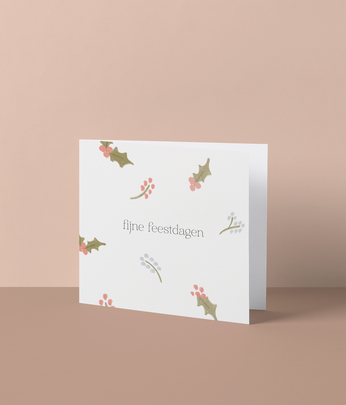 Kerstkaart met verspreide hulsttakjes in groen, roze en blauwgrijs en de tekst 'fijne feestdagen', losse kaart van Studio Mie